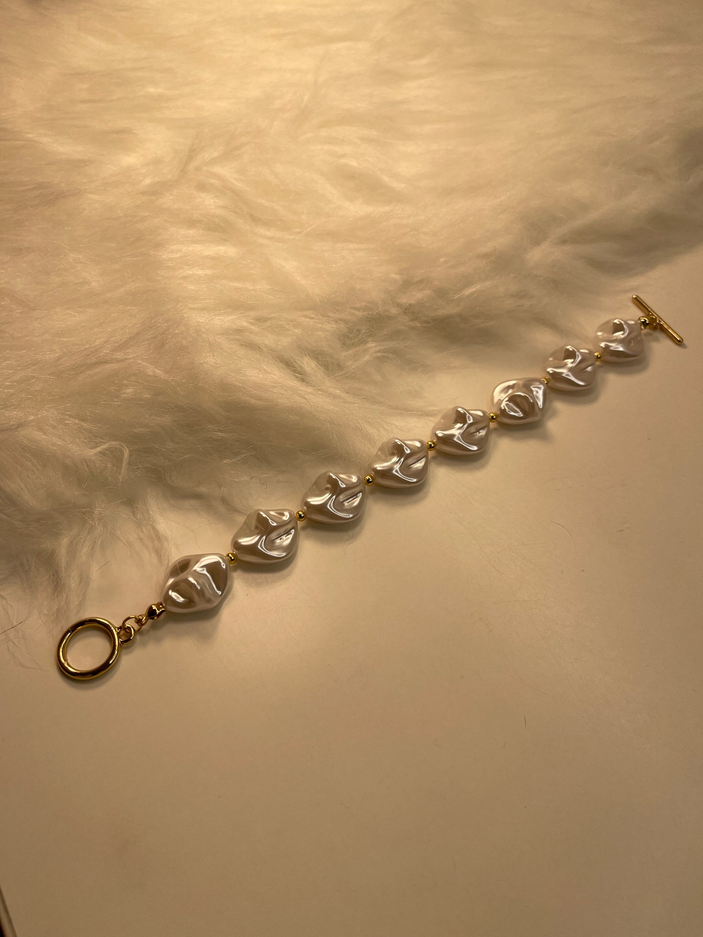 Pearl Bracelet with heart-shaped beads on a textured beige background