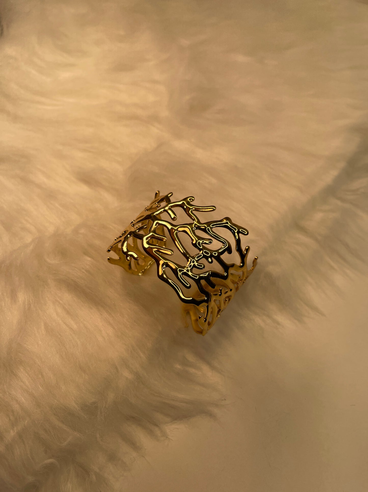 Gold Bracelet on a textured beige surface