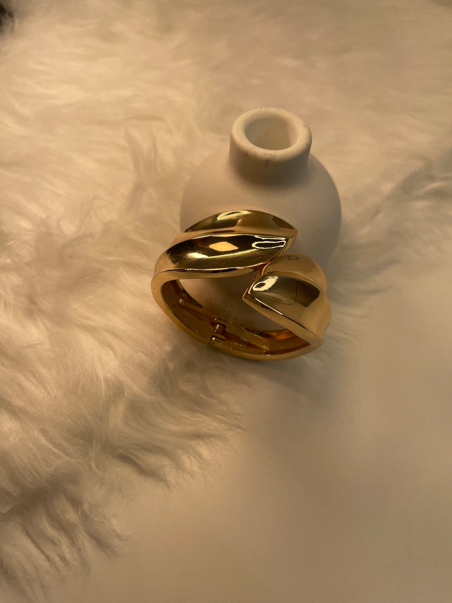 Gold Bracelet on a textured beige surface