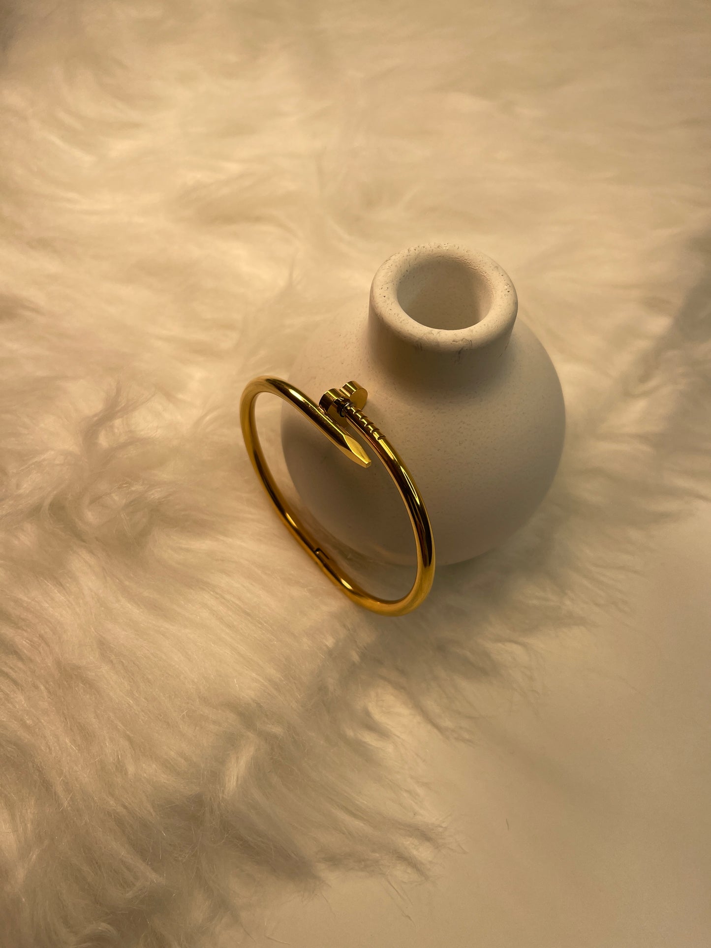 Gold Nail Bracelet on a textured beige surface