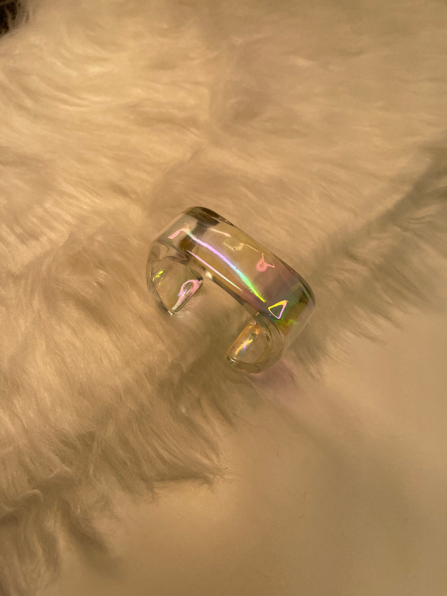 Clear Bracelet with a flat iridescence design on a textured beige surface