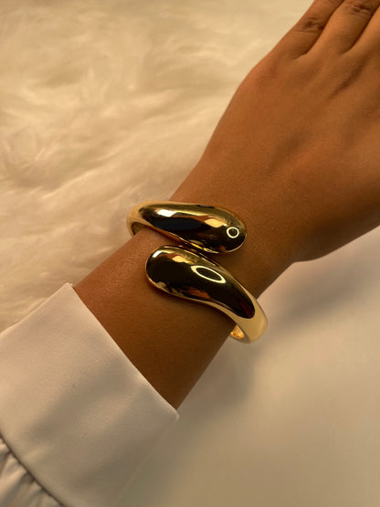 Gold Cuff Bracelet on a wrist with a white shirt sleeve