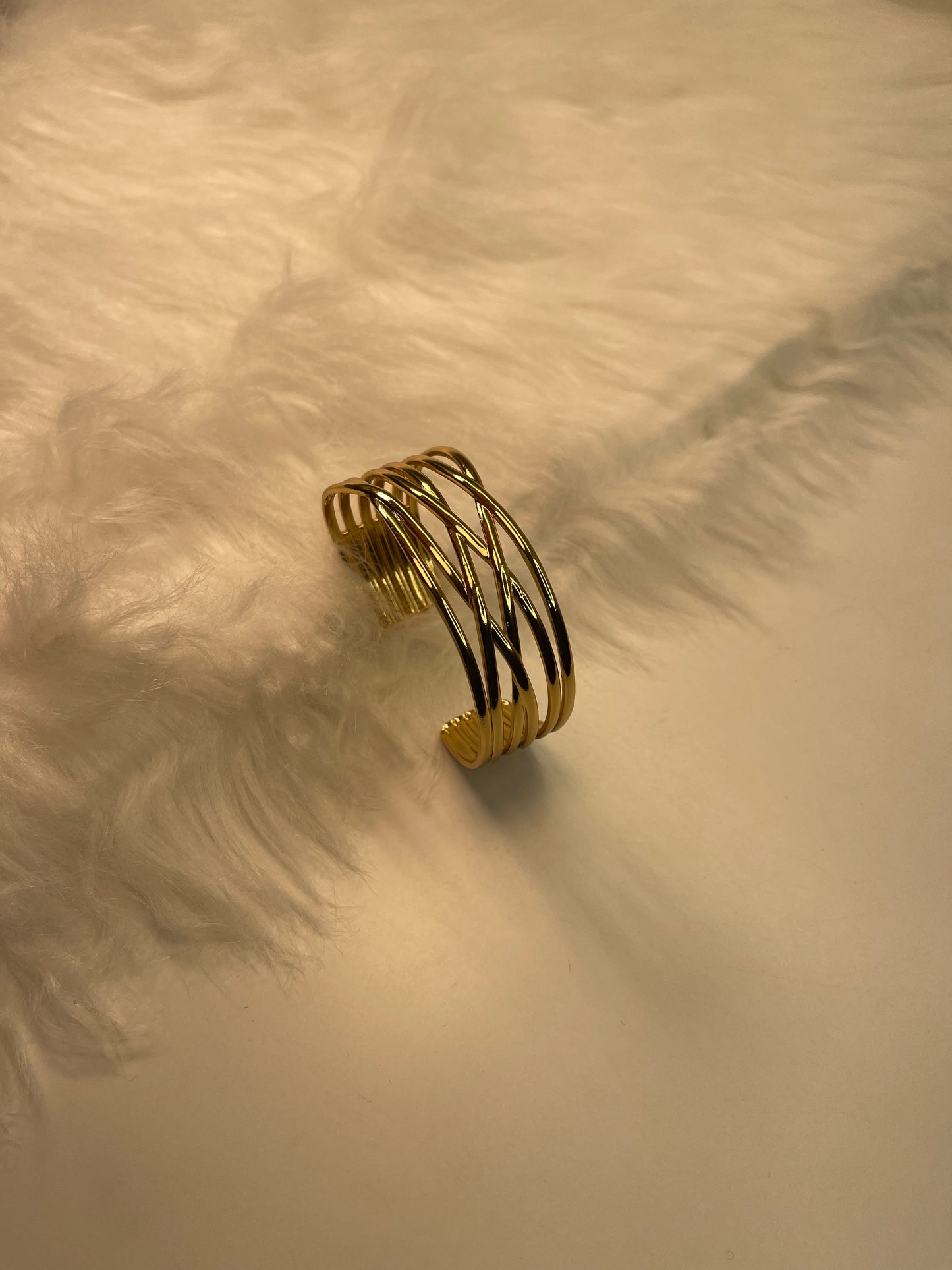 Gold Bracelet on a textured beige surface