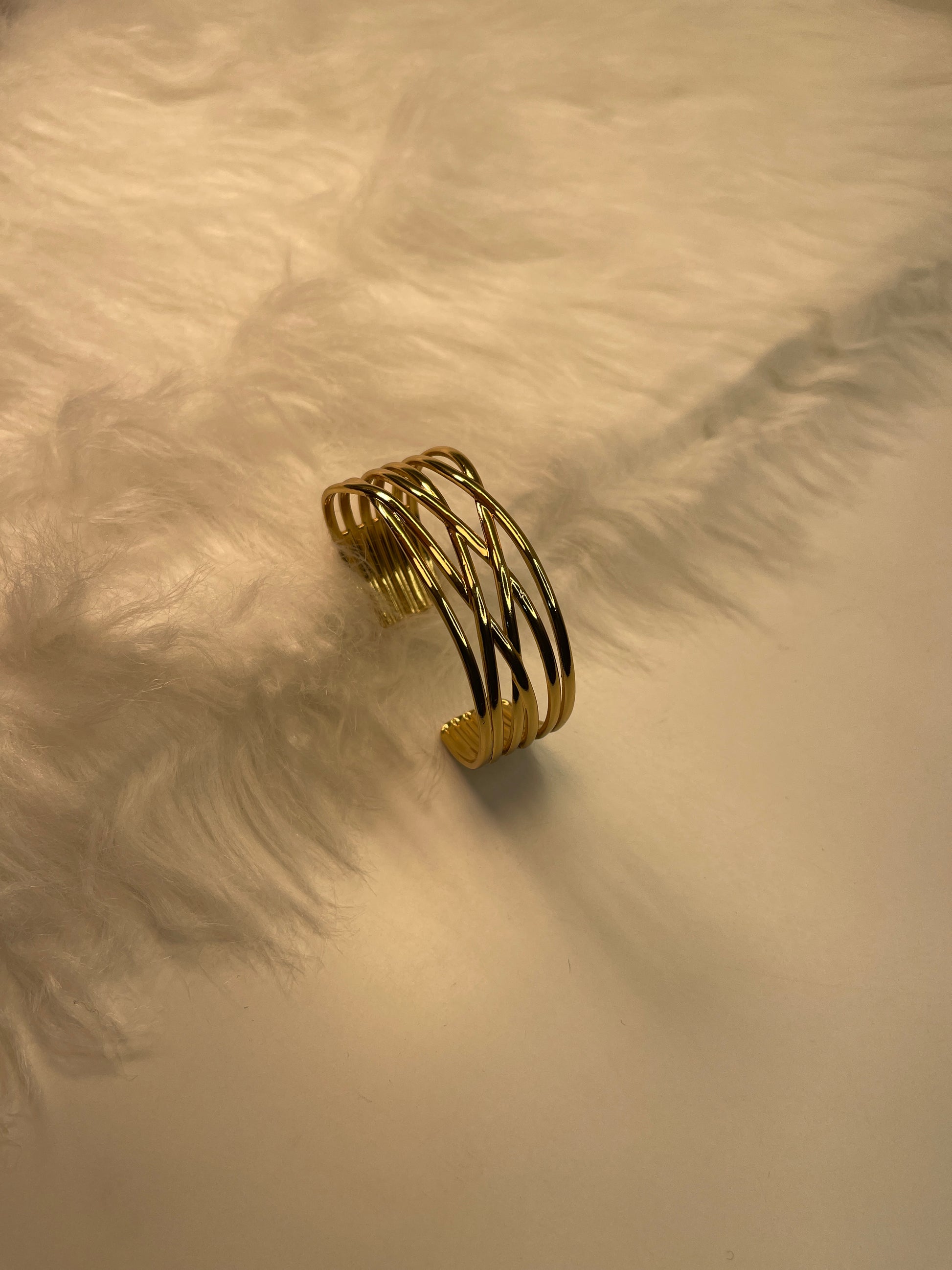 Gold Bracelet on a textured beige surface