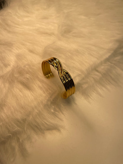 Gold bracelet on a textured beige surface