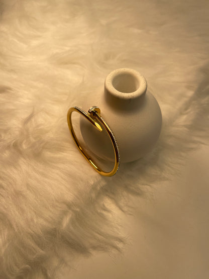 Gold Nail Bracelet on a textured beige surface