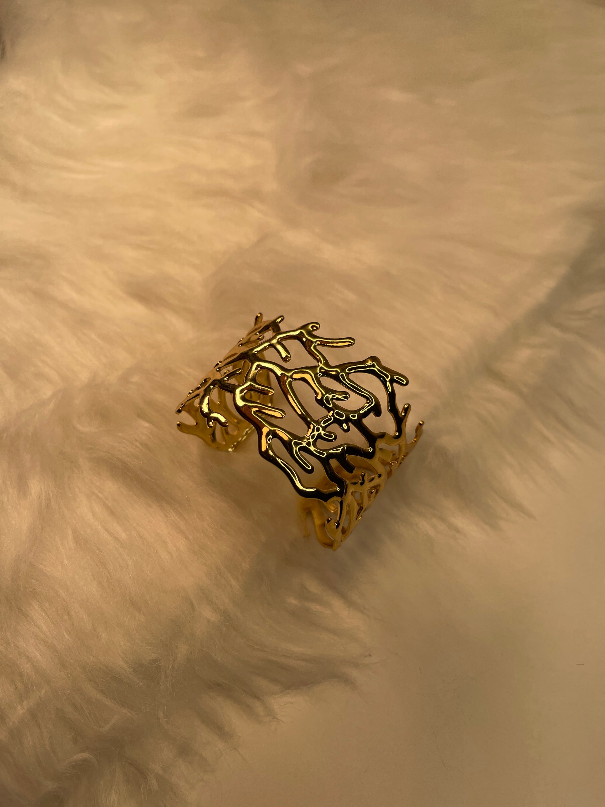 Gold Bracelet on a textured beige surface