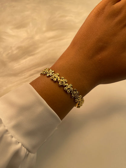 Gold bracelet on a wrist with a blurred background