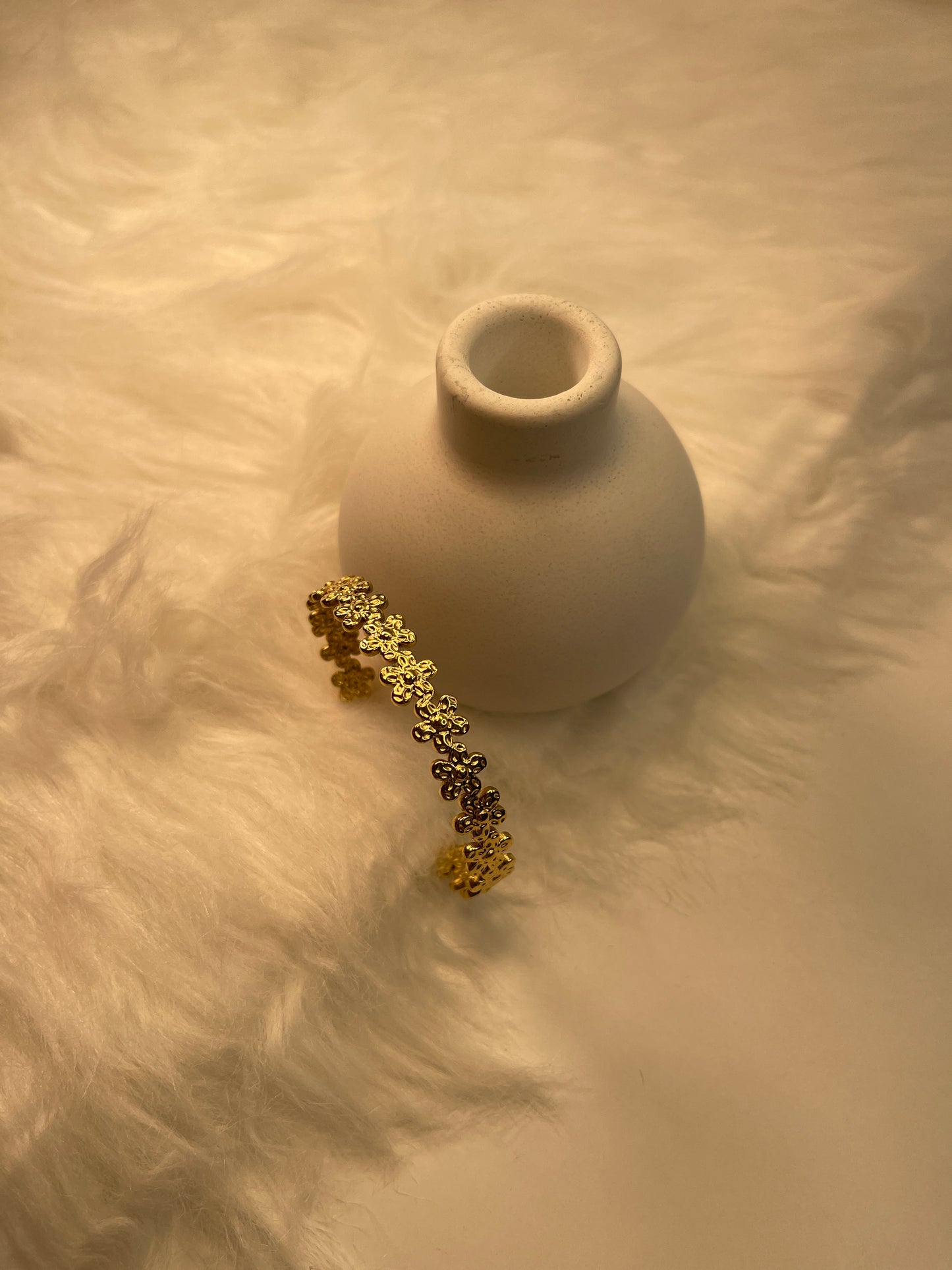 Gold Flower Bracelet on a textured beige surface