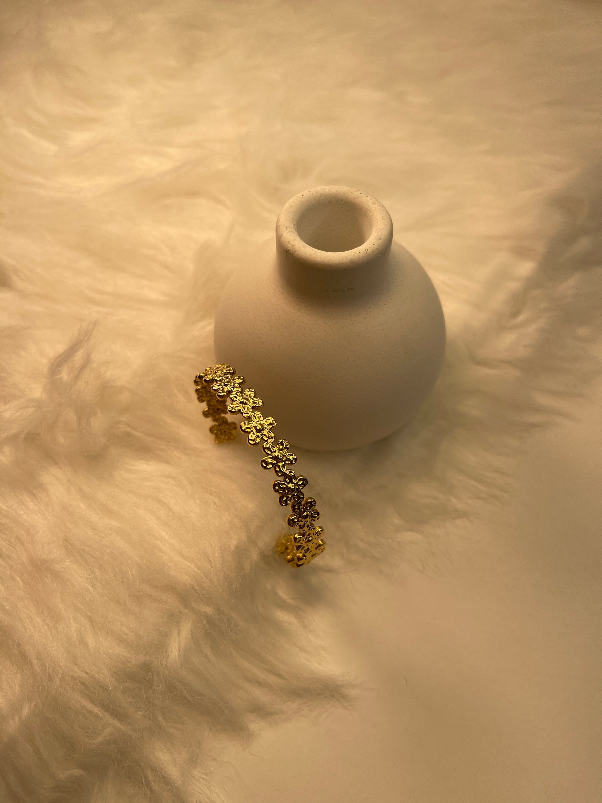 Gold Flower Bracelet on a textured beige surface