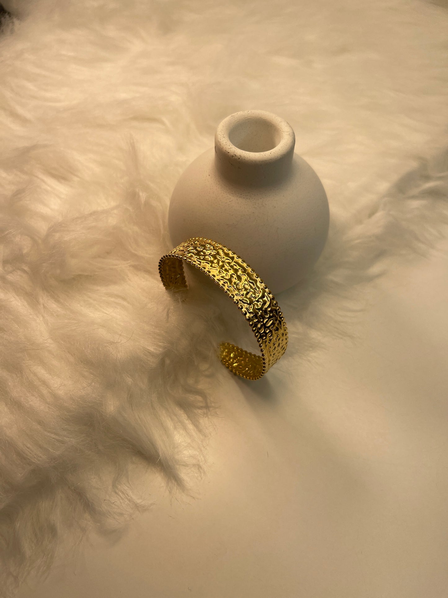 Gold bracelet on a textured white surface