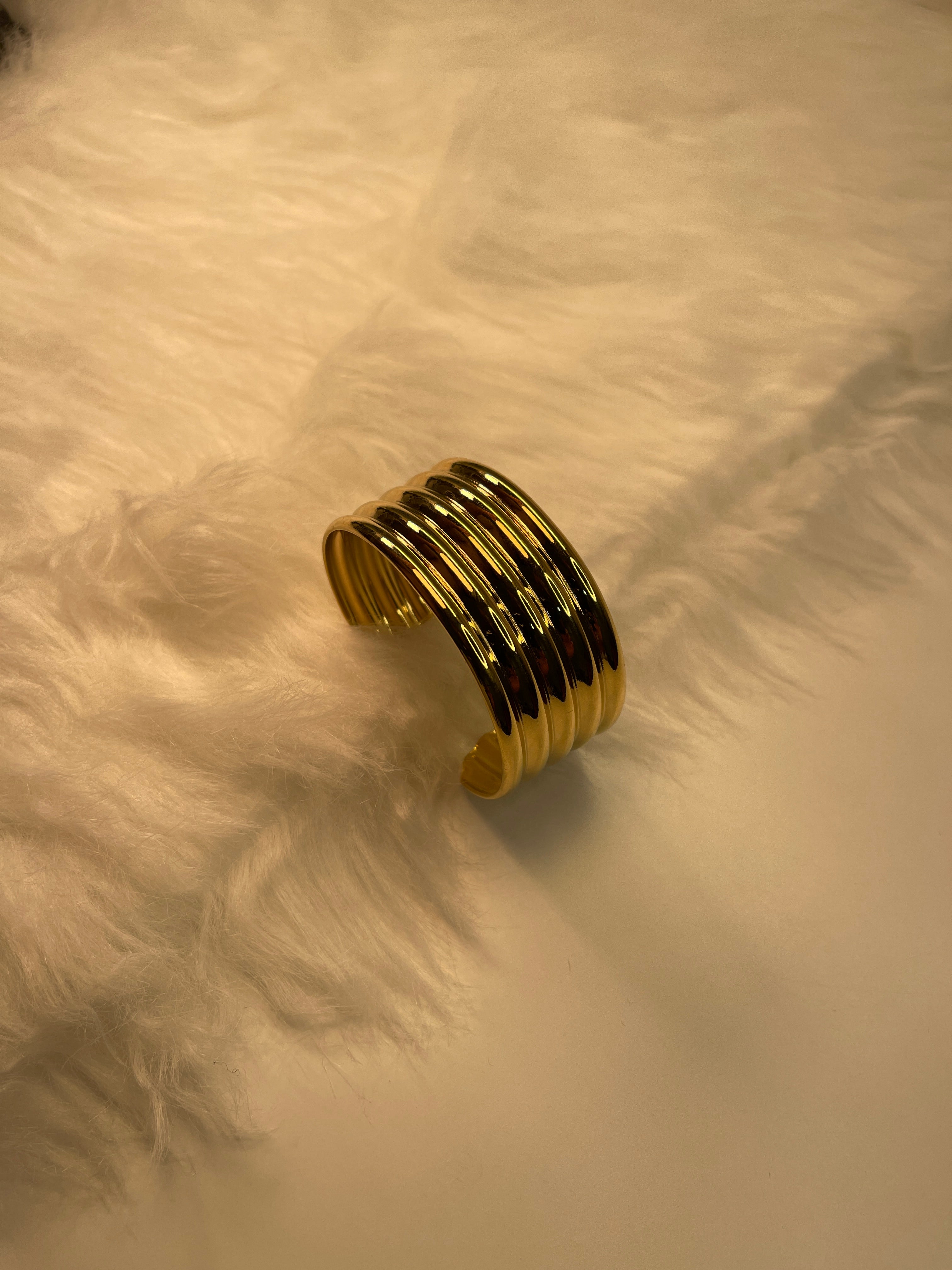 Gold bracelet on a textured beige surface