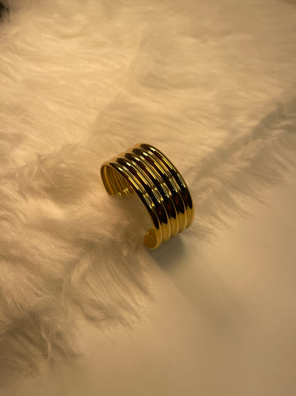 Gold bracelet on a textured beige surface