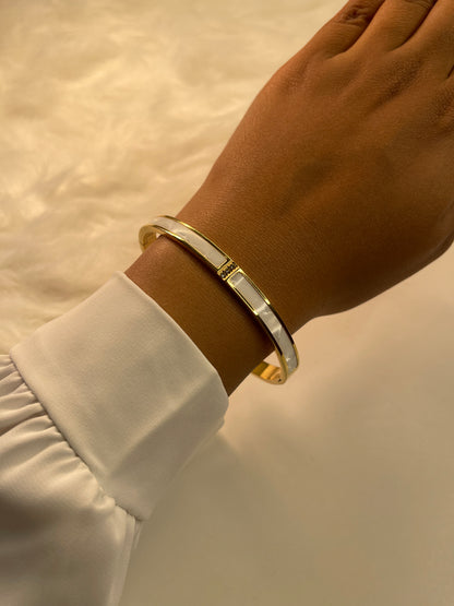 Gold bracelet on a wrist with a blurred background