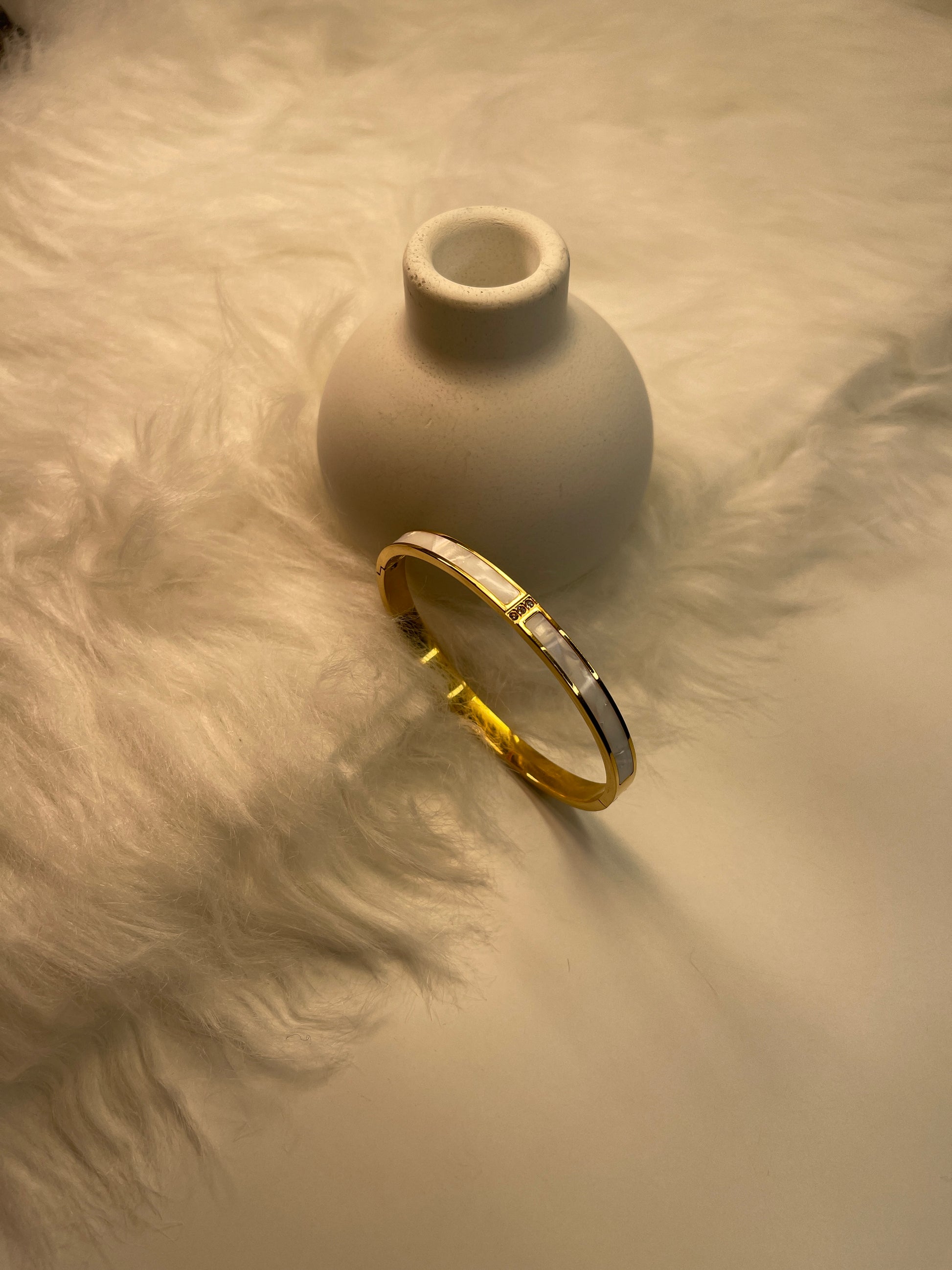 Gold Bracelet on a textured beige surface