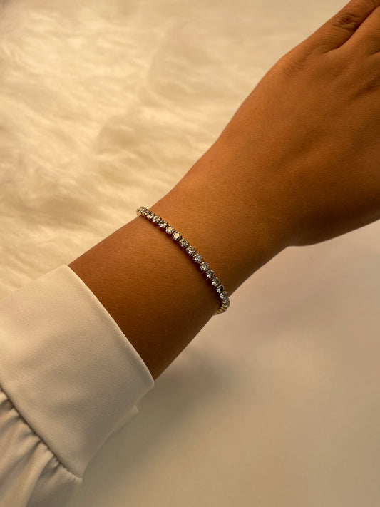 Close-up of a wrist wearing a Tennis bracelet on a neutral background