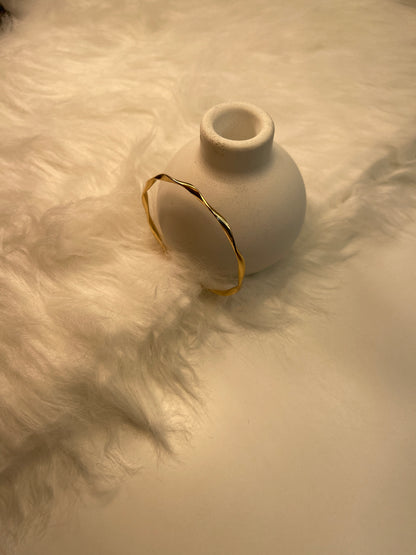 Gold Bracelet on a textured white surface