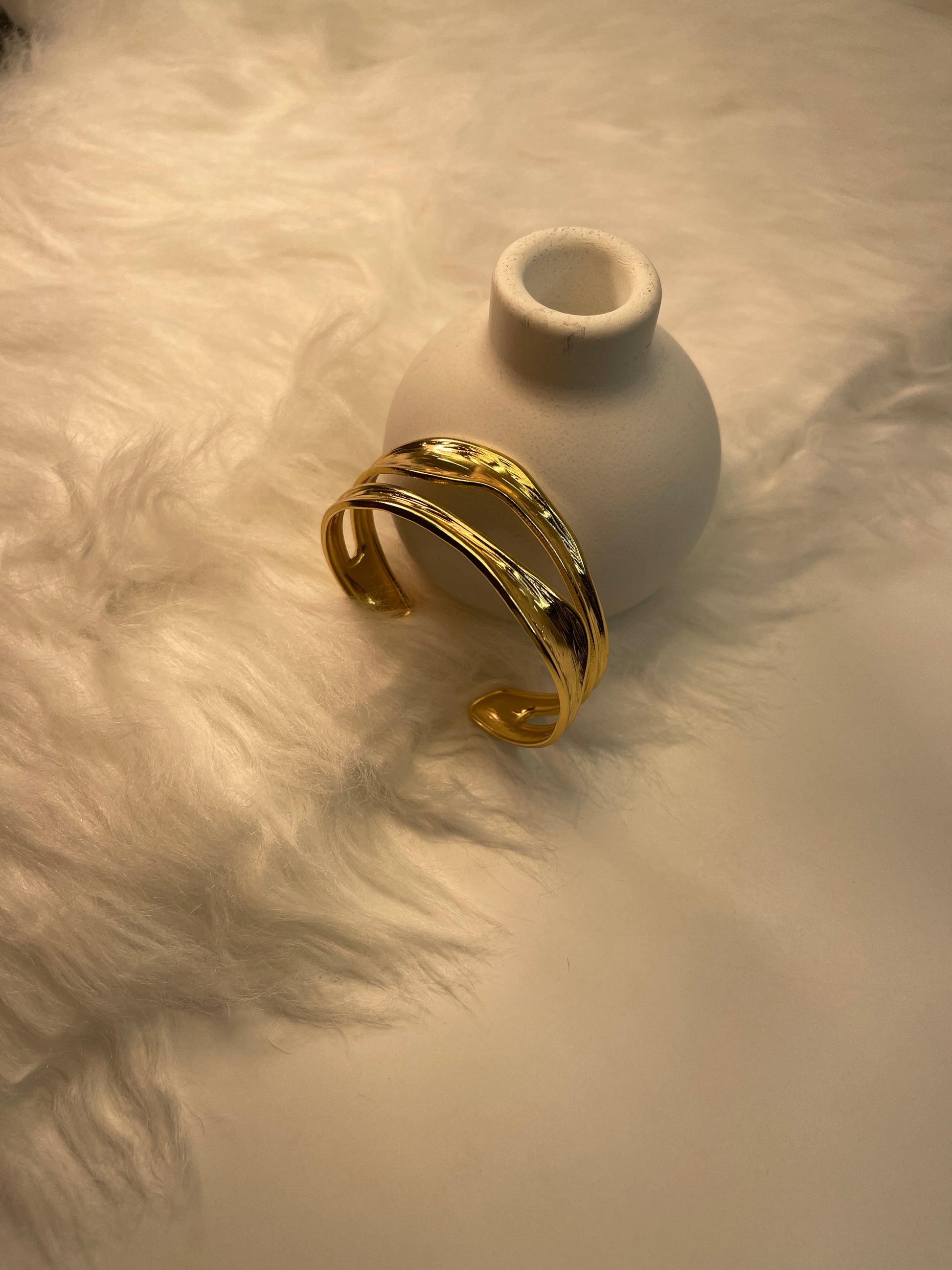 Gold bracelet on a textured white surface