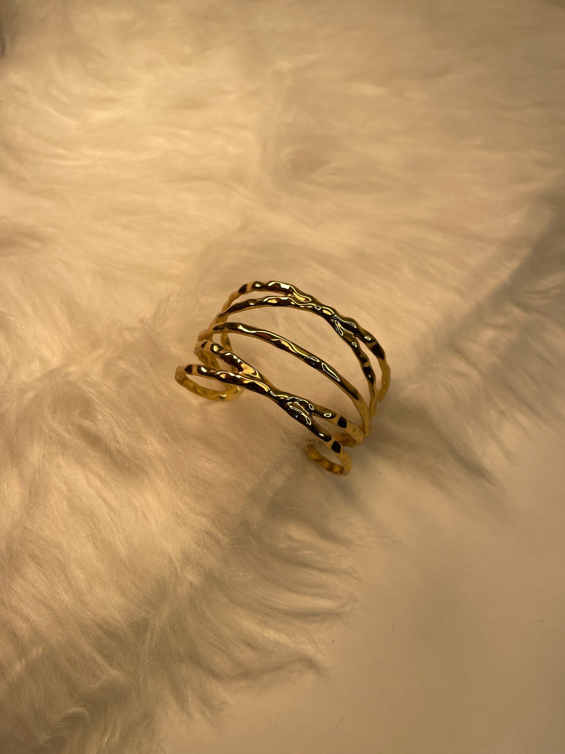 Gold bracelet on a textured beige surface