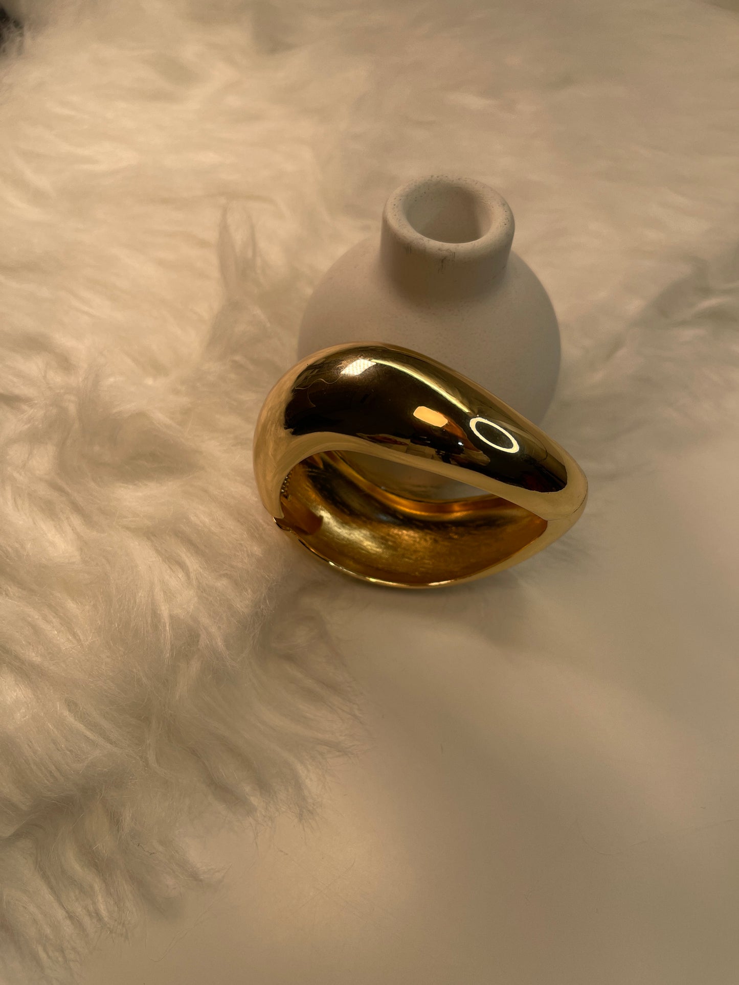 Gold Bracelet on a textured white surface